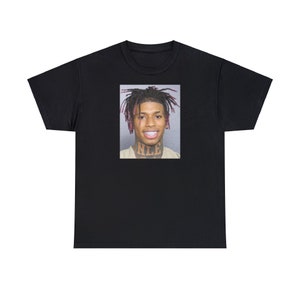 May include: Black t-shirt with a photo of a man with pink hair and a tattoo on his neck that says "NLE".