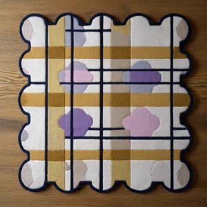 Op de afbeelding: Een decoratief vloerkleed met een unieke geschulpte rand. Het vloerkleed heeft een rasterpatroon met mosterdgele en witte strepen, geaccentueerd door marineblauwe lijnen en wolkachtige ontwerpen in lavendel en roze. Het vloerkleed is vierkant van vorm.