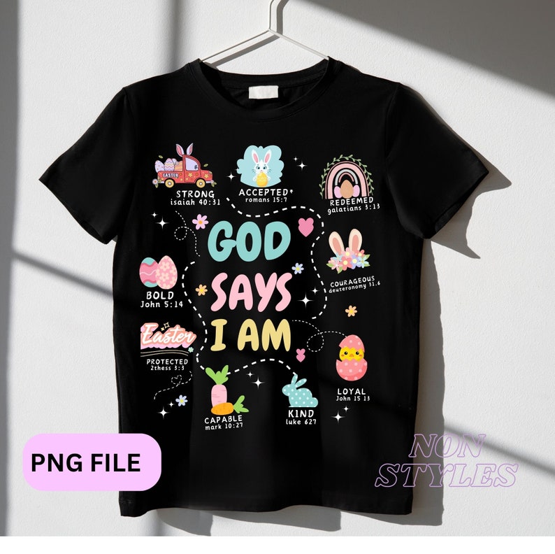 May include: Black t-shirt with a colorful Easter-themed design. The text "God Says I Am" is surrounded by images of bunnies, eggs, and carrots. Each image has a Bible verse associated with it.