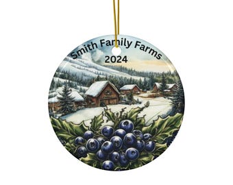 May include: A circular ceramic Christmas ornament with a winter farm scene and blueberries. The ornament features a snowy landscape with buildings and the text "Smith Family Farms 2024". A cluster of blueberries and green leaves are at the bottom.