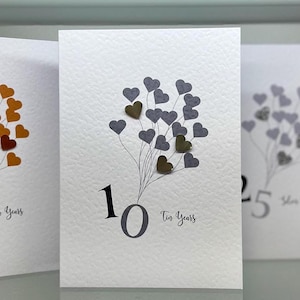 Tarjeta de aniversario de hojalata auténtica. Tarjeta de décimo aniversario hecha a mano. Tarjeta de aniversario de bodas, hecha a mano con corazones de hojalata auténtica.