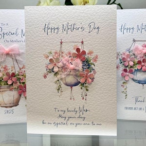 Tarjeta para el Día de la Madre, hecha a mano. Tarjeta para el Día de la Madre de lujo con flores en 3D, cinta y gemas. Cesta colgante con acuarela