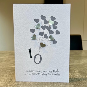 Biglietto di anniversario in latta vera. Biglietto di anniversario di matrimonio della moglie per il decimo anniversario. Biglietto di anniversario di dieci anni fatto a mano. Fatto a mano con cuori di latta vera, anno di latta