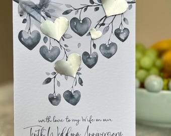 Kaart vrouw 10e huwelijksverjaardag. Echte blikken jubileumkaart. Handgemaakte tienjarige jubileumkaart. Handgemaakt met tinnen hartjes, edelstenen en een strik