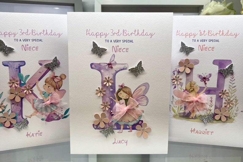 May include: Three handmade birthday cards featuring a purple letter, a fairy, and flowers. The cards say "Happy 3rd Birthday to a very special Niece" and include the names Katie, Lucy, and Harriet.