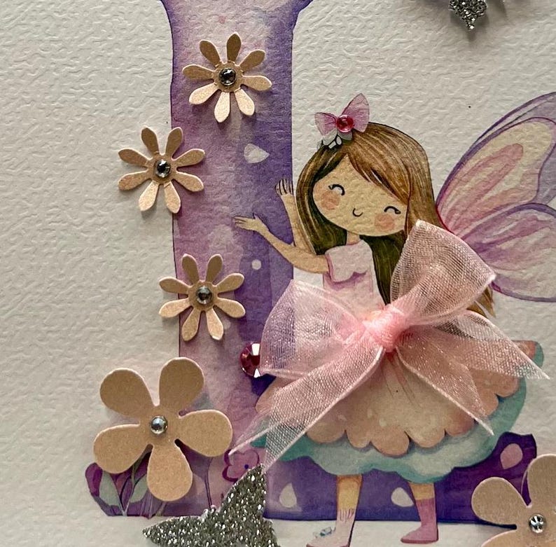 May include: A purple and pink fairy with brown hair and a pink bow is holding a pink ribbon. The fairy is standing in front of a purple letter I with pink flowers and glitter.