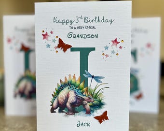 May include: A birthday card with the text "Happy 3rd Birthday" and "To a very special Grandson". The card features a dinosaur illustration, butterflies, stars, and the name "Jack".
