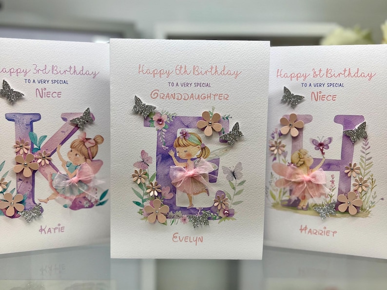May include: Three handmade birthday cards with purple letters, glitter, and a fairy illustration. The cards say "Happy 3rd Birthday to a very special Niece Katie", "Happy 6th Birthday to a very special Granddaughter Evelyn", and "Happy 1st Birthday to a very special Niece Harriet".