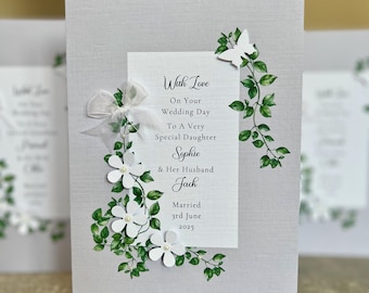 Puede incluir: Una tarjeta blanca con un diseño floral y el texto "With Love On Your Wedding Day To A Very Special Daughter Sophie & Her Husband Jack Married 3rd June 2025"