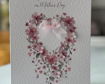 May include: A white card with a pink floral heart design and the text "To my Beautiful Mum on Mother's Day".