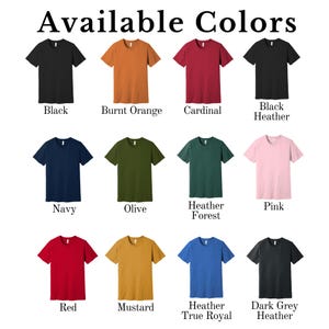 K&ouml;nnte beinhalten: Eine Tabelle mit 12 verschiedenen T-Shirt-Farben, darunter Schwarz, gebranntes Orange, Kardinalrot, Marineblau, Olivgr&uuml;n, Heidekrautwald, Rosa, Rot, Senfgelb, Heidekraut-Royalblau und Dunkelgrau-Heidekraut.