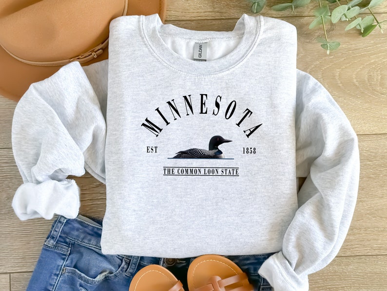 May include: Gray sweatshirt with a black graphic design that says "Minnesota Est. 1858 The Common Loon State" with a black loon illustration.