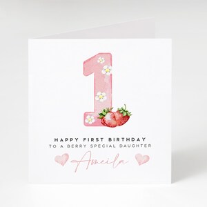 May include: Pink card with a watercolor illustration of the number one with strawberries and flowers. The text reads "Happy First Birthday to a Berry Special Daughter Amelia".