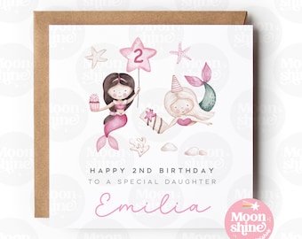 Puede incluir: Una tarjeta de cumpleaños rosa y blanca con una ilustración de acuarela de dos sirenas sosteniendo una estrella con el número 2. La tarjeta dice "Feliz 2º cumpleaños a una hija especial Emilia" y tiene un pequeño logotipo que dice "Moonshine wishes".