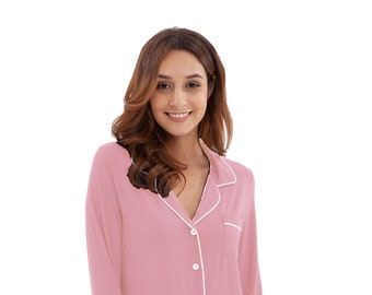 May include: A pink pajama set with long sleeves and pants. The top has a white collar and white piping around the edges. The top has a button-up front.