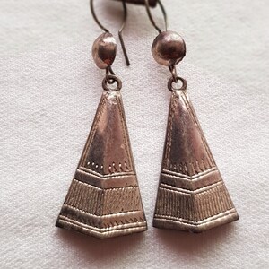 Peut inclure: Une paire de boucles d'oreilles pendantes en argent de forme triangulaire avec des motifs gravés complexes. Les boucles d'oreilles ont une fermeture simple à crochet.