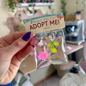 May include: A white ceramic mug with a black handle and the text "But First, Coffee" in a bold, black font. The mug is set against a neutral background, highlighting its simple design.