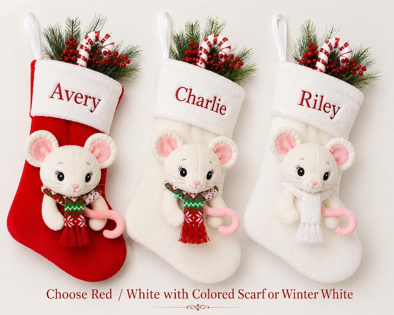 Op de afbeelding: Drie kerstsokken met pluche witte muizen met roze oren. E&eacute;n sok is rood, twee zijn wit. Elke sok heeft een witte boord met de namen Avery, Charlie of Riley. De muizen dragen sjaals en houden zuurstokken vast.