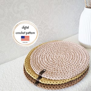Könnte beinhalten: Drei gehäkelte runde Tischsets in Braun-, Beige- und Gelbtönen, übereinander gestapelt. Ein Lederriemen ist an der Seite befestigt. Das Bild enthält eine kreisförmige Grafik mit dem Text "digital crochet pattern" und der amerikanischen Flagge.