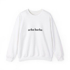 May include: White sweatshirt with the text "acha bacha" printed in black on the front.