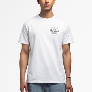 Può includere: T-shirt bianca con testo nero: "Phil Collins Rock & Roll Hall of Fame Class of 2023" e l'hashtag "#gotphilvotedin". La maglietta ha maniche corte e girocollo.
