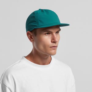 May include: A teal baseball cap with a short peak. The cap is made of a lightweight material and has a simple design. The cap is worn by a person wearing a white t-shirt. The cap is a vibrant shade of teal.