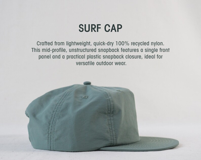 May include: A teal Surf Cap made from recycled nylon. The unstructured snapback hat has a single front panel and a plastic snapback closure. The text "SURF CAP" is at the top.