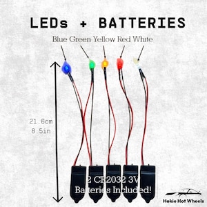 May include: Five LED light sets with black battery packs, each featuring a blue, green, yellow, red, or white bulb. The wires measure 8.5 inches long. Text reads: LEDs + BATTERIES, Blue Green Yellow Red White, 2 CR2032 3V Batteries Included!