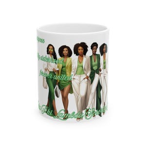 Op de afbeelding: Witte keramische mok met een illustratie van vrouwen in groene en witte kleding. De mok heeft groene tekst: "Purpose, by sisterhood, forever united, Phi Lambda Sorority".