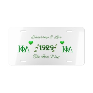Może przedstawiać: Biała tablica rejestracyjna z zielonym tekstem i sercami. Tekst brzmi "Leadership & Love", "IΦΛ", "1929", "IΦΛ" i "The Iota Way".