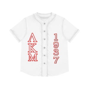 Op de afbeelding: Wit honkbalshirt met rode letters en cijfers. De linkerkant heeft de letters "ΛKM" verticaal gestapeld en de rechterkant toont het nummer "1937". De trui heeft een knoopsluiting aan de voorkant en korte mouwen.