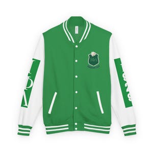 Op de afbeelding: Groene en witte varsity jas met een knoopsluiting. De jas heeft witte mouwen en een groene body. Een wapen met tekst staat op de borst en tekst op de mouwen. De jas heeft een geribbelde kraag, manchetten en zoom.