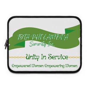 Pode incluir: Uma capa para laptop branca com um design de fita verde. A fita tem o texto "IOTA PHI LAMBDA Sorority Inc." e "Unity In Service" em texto verde. O texto "Empowered Women Empowering Women" também está na capa.