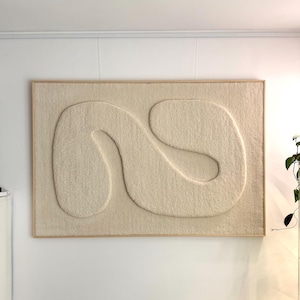May include: A rectangular wall art piece featuring a cream-colored, textured, tufted fabric surface with a raised, continuous, winding abstract shape in the center, all enclosed within a light-toned wooden frame.