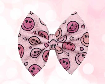 Laço rosa com carinhas sorridentes para bebês e crianças pequenas