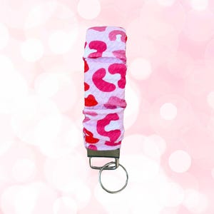 Peut inclure: Porte-clés imprimé léopard rose et blanc avec un anneau de clé argenté.