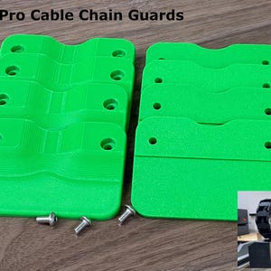 May include: Bright green Shapeoko 5 Pro cable chain guards with mounting hardware. The guards are stacked in two groups on a wooden surface. The text "Shapeoko 5 Pro Cable Chain Guards" is at the top of the image.