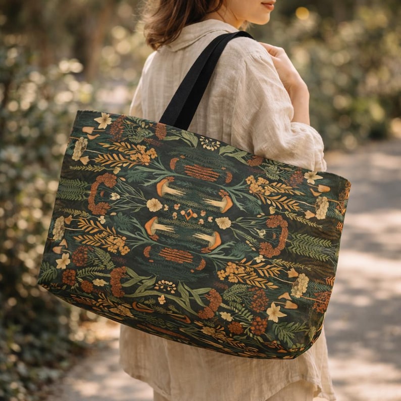 Large moody botanical tote bag carried by woman outdoors, dark green cottagecore weekender bag with nature-inspired pattern, aesthetic everyday travel tote