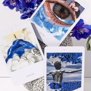 May include: Three tarot cards with surreal imagery, including an eye, a figure in water, and a person on a blue cloth. The cards are accompanied by vibrant purple flowers in a textured vase. The text on the cards reads "True Time", "Brother Rain", and "Sacred Centre".