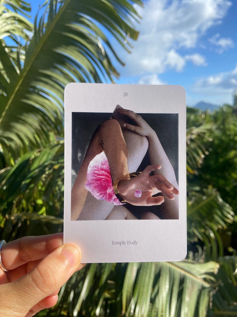 May include: A rectangular card with the number 28 at the top features a black and white image of a person's arms and legs, a pink flower, and a hand with a gold bracelet. The text "Temple Body" is at the bottom of the card.