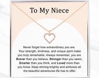 May include: A gold-colored necklace with a heart-shaped pendant, presented in a white gift box. The pendant is encrusted with small, clear crystals. The text "To My Niece" is displayed above the necklace, with an inspirational message below.