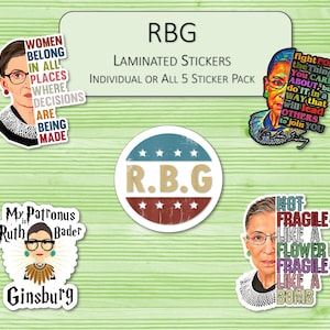 May include: A collection of laminated stickers featuring images of Ruth Bader Ginsburg. The stickers include quotes and phrases such as "Women Belong in All Places Where Decisions Are Being Made" and "Fight for the Things You Care About".