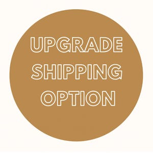 Può includere: Grafica rotonda color marrone con la scritta bianca "UPGRADE SHIPPING OPTION". Il testo è impilato verticalmente in tre righe. Lo sfondo è marrone pieno, con il testo centrato.