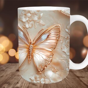May include: White ceramic mug featuring a detailed, embossed design of a butterfly with gold and pearl accents, surrounded by floral elements. The mug has a white handle and a cream-colored background.