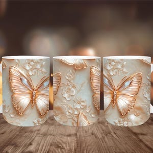 May include: Three white ceramic mugs with a repeating butterfly design. The butterflies are gold with white and blue accents, set against a cream-colored background with floral details. The mugs have white handles.