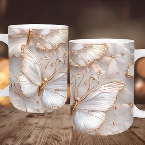 May include: White ceramic coffee mug featuring a detailed butterfly design with gold accents. The butterfly wings are white with gold trim and are set against a white floral background. The mug has a white handle.
