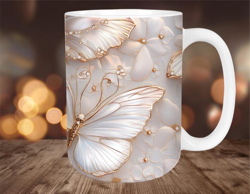 May include: White ceramic mug featuring a 3D butterfly and floral design. The butterfly has white wings with gold accents and is adorned with small crystals. The background has a soft, blurred effect.