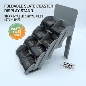 Peut inclure: Un présentoir pliable gris pour dessous de verre en ardoise. Le présentoir est intitulé "FOLDABLE SLATE COASTER DISPLAY STAND". Les dessous de verre portent des mots imprimés liés aux boissons, tels que "WHISKEY", "RUM" et "GIN". L'image comprend également le texte "DIGITAL FILES ONLY".