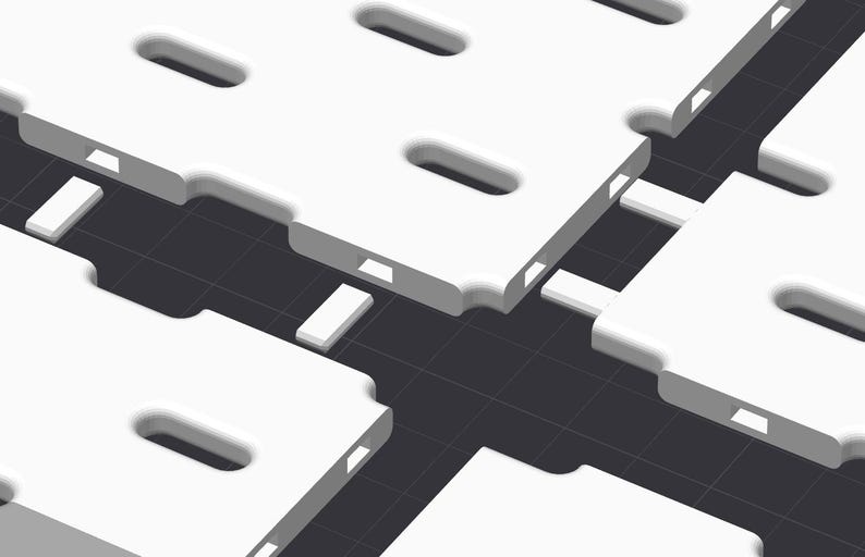 May include: A series of white, rectangular modular panels featuring rounded corners and elongated oval cutouts. Each panel has small, rectangular connector tabs along the edges, arranged in a grid pattern against a dark gray background.
