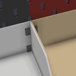May include: A modular storage system featuring white and beige panels connected by dark gray plastic clips. The assembly is positioned in front of a dark gray and red perforated pegboard wall panel with visible slots for mounting accessories.